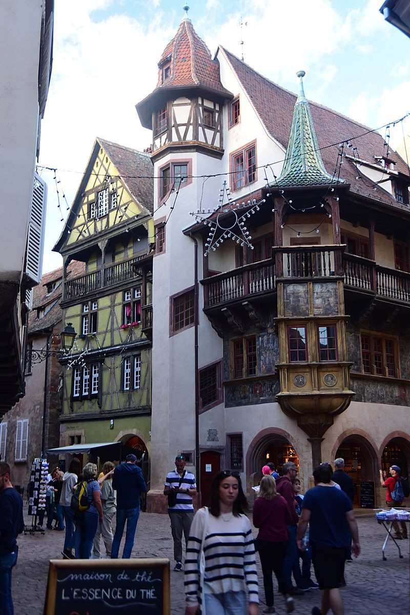 Colorful half-timbered buildings along a cobblestone street in Colmar's old town.