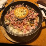 Traditional Alsatian potato and Munster cheese dish served in a cast-iron skillet.