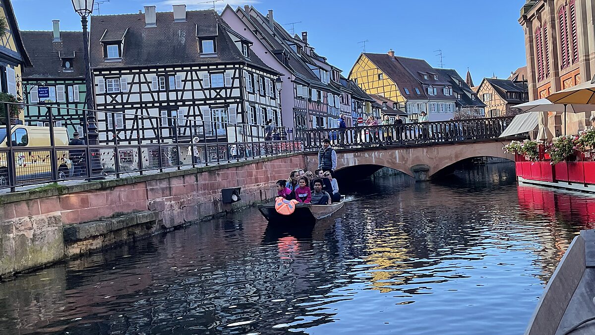 Small sightseeing boat cruising through Petite Venise in Colmar.